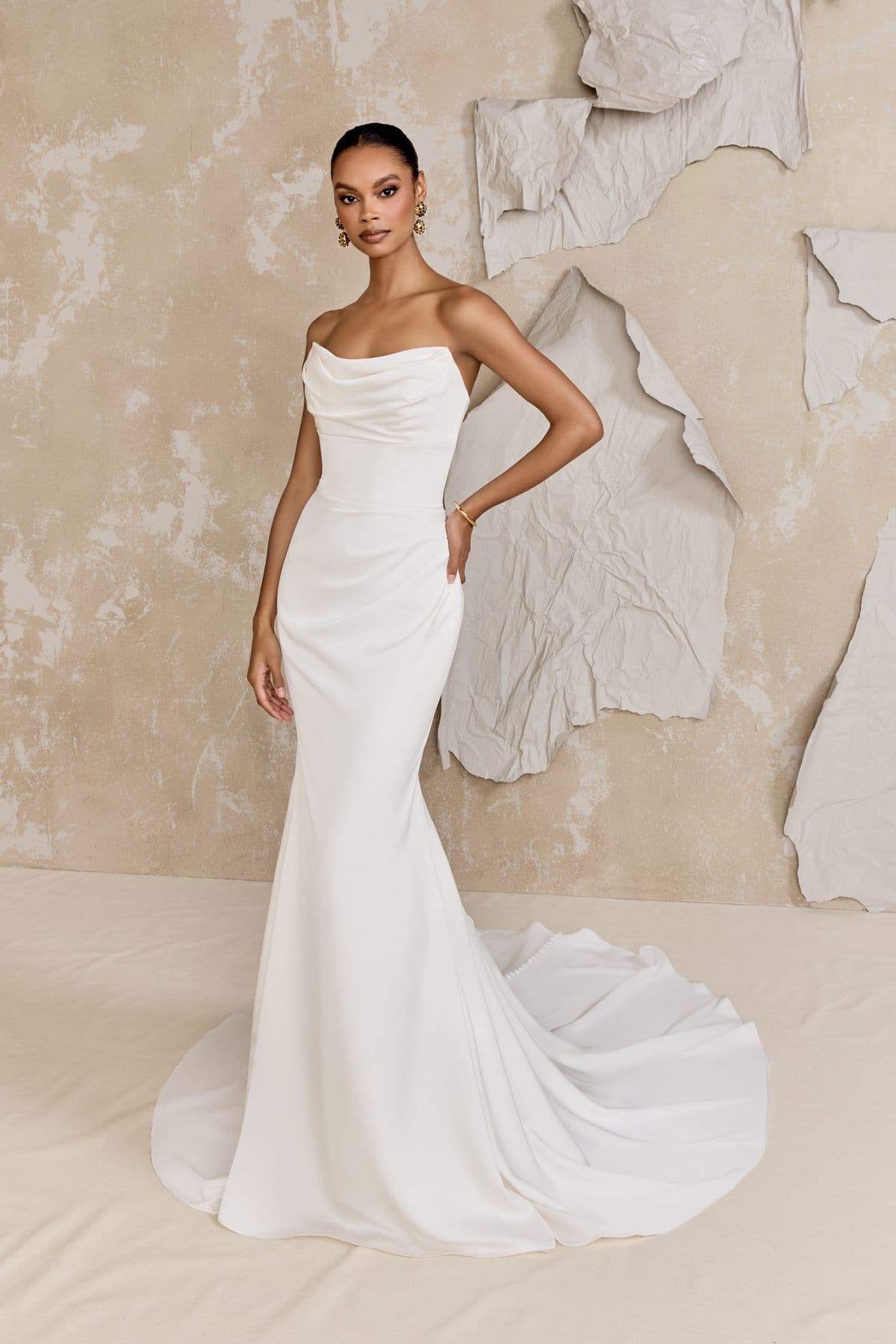 Atwood by Justin Alexander, a fitted bridal gown against a sculptural wall
