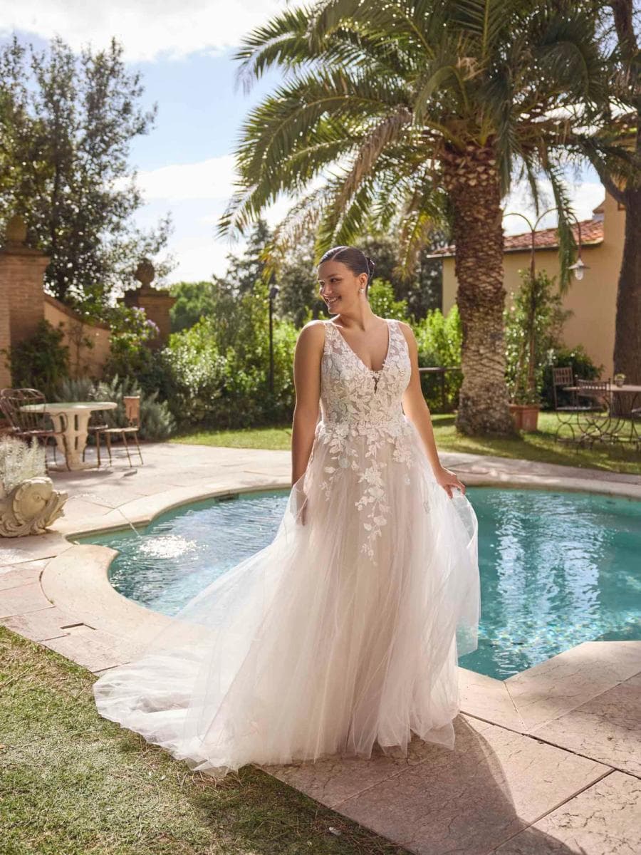 Jolanthe by Modeca, a floral lace bridal gown beside a pool