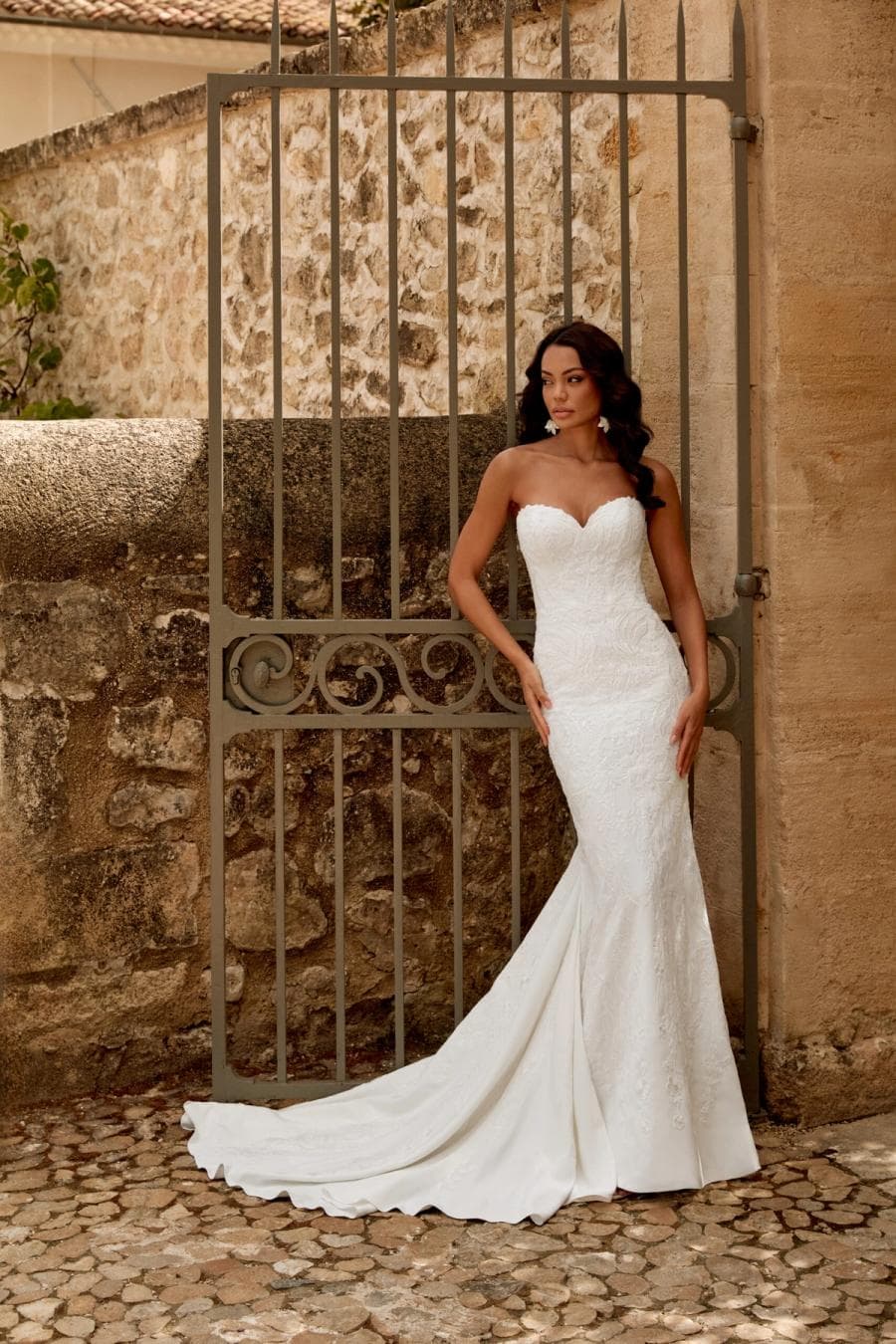 Louise by Sincerity, a lace bridal gown at a historic stone gate
